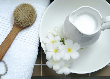Jug of milk, flowers, body brush and towelの写真素材