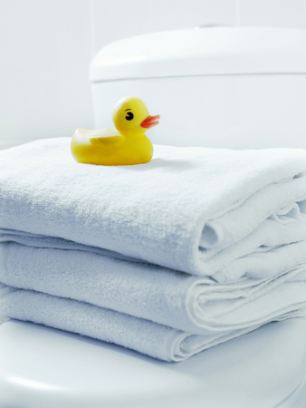 Rubber duck on a stack of towelsの写真素材