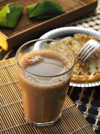 piece of roti canai and a glass of teh tarikの写真素材