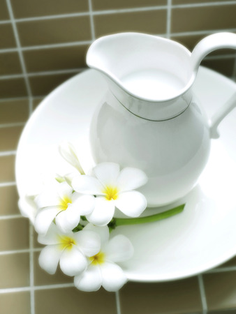 A jug of milk and flowersの写真素材