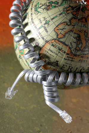 Phone cords being tied around a globe