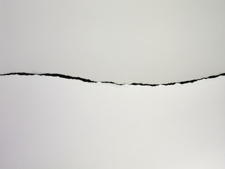 torn or tearing paper into two piecesの写真素材