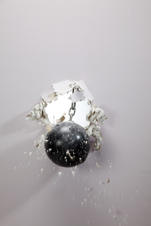 metal ball cracking down a wallの写真素材
