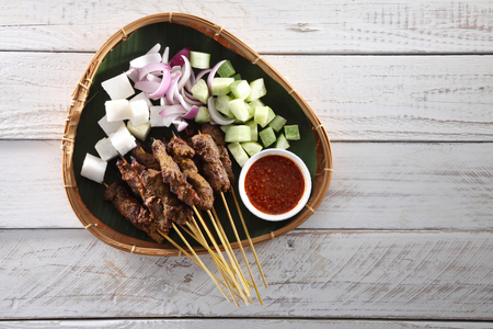Malaysian famous food satay on bamboo basket with the cucumber and ketupatの写真素材