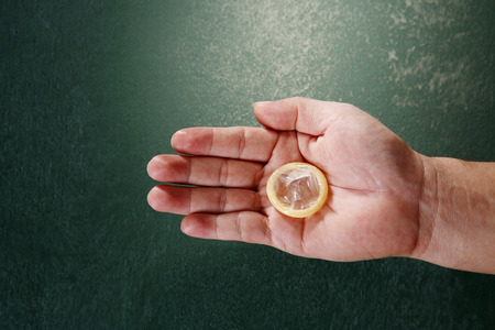 man hand holding a condomの写真素材