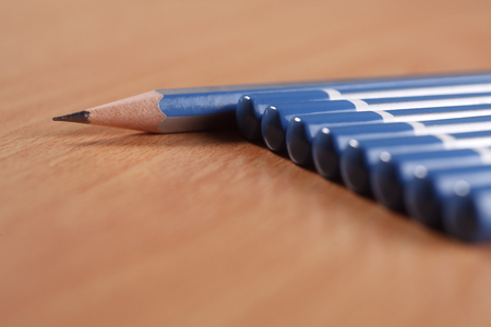 A sharpened pencil among a row of blunt end pencilsの写真素材