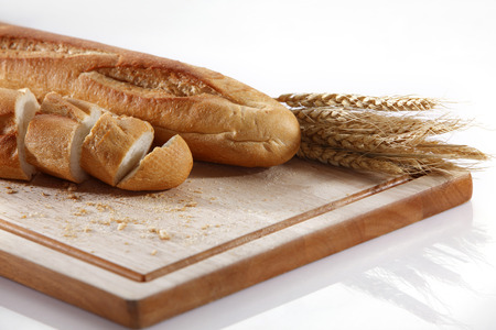Baguette with wheat on the chopping board.の写真素材