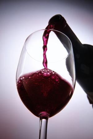 Pouring wine into a wine glass.の写真素材