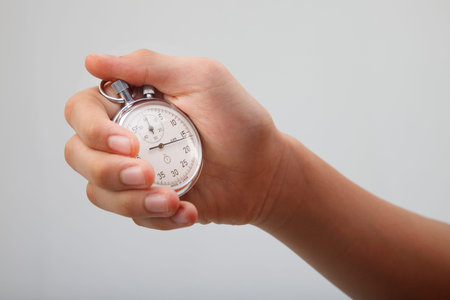 man holding a stop watch on the plain background