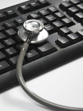 stethoscope resting on the key boardの写真素材