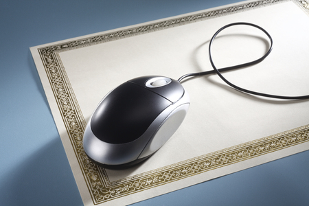 diploma and mouse on the blue backgroundの写真素材