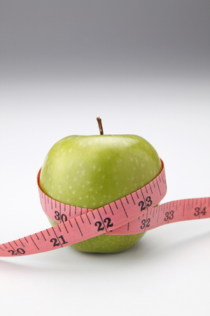 stock image of the measuring tape on appleの写真素材