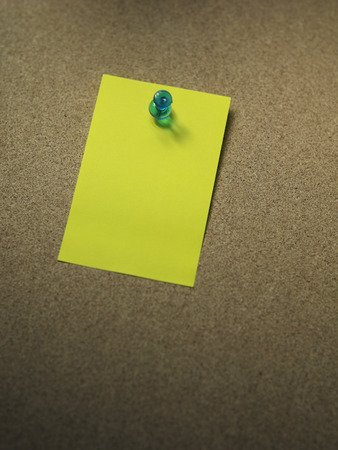 a thumbtuck on the yellow blank noteの写真素材