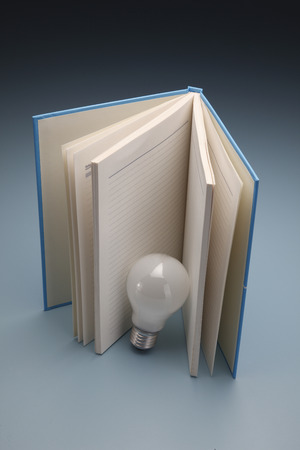 A book and lamp, isolated on dark background for concept ideaの写真素材
