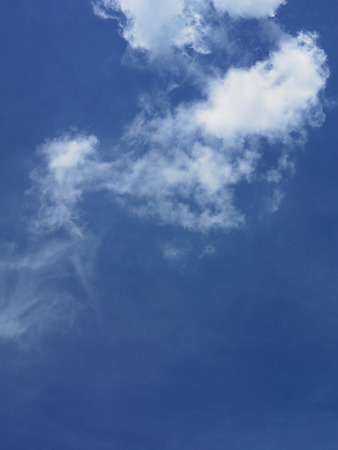 white fluffy clouds in the blue skyの写真素材
