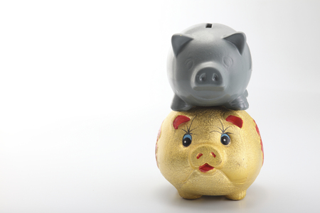 Golden Pig piggy bank with another grey piggy bank on top.の写真素材