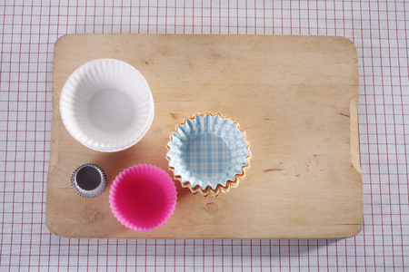 Cupcake molds on chopping board.の写真素材