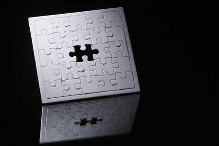 Jigsaw puzzle with missing piece isolated on black background.の写真素材