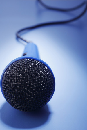 Blue microphone isolated on the blue background.の写真素材