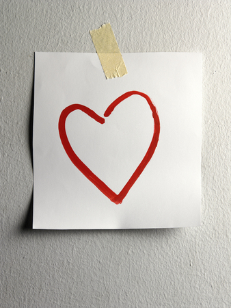 paper painted with heart shape stick on the wallの写真素材