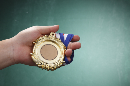 Human hand holding a medal.の写真素材