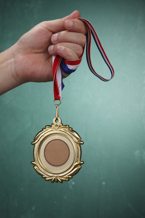 Human hand holding a medal.の写真素材
