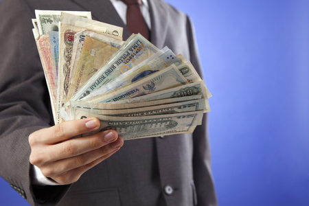 man showing currency of many countryの写真素材