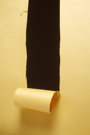 stock image of the hole on the orange color paperの写真素材