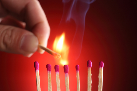 Light match near row of unlit matchesの写真素材