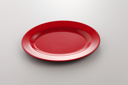 Empty red plate on the white backgroundの写真素材