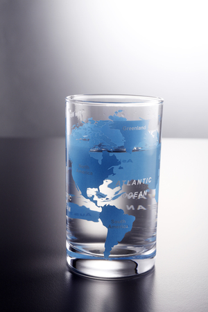 water in a glass printed world mapの写真素材