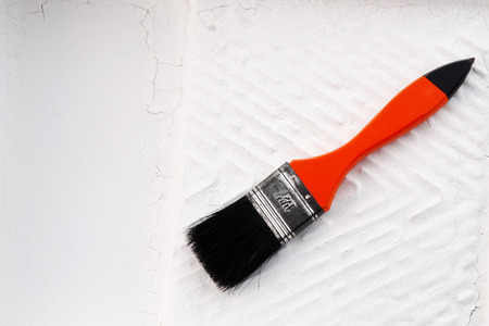 painting brush lying in a used paint trayの写真素材