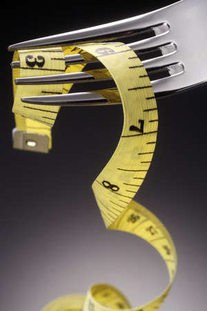 fork and measuring tape on the gray backgroundの写真素材