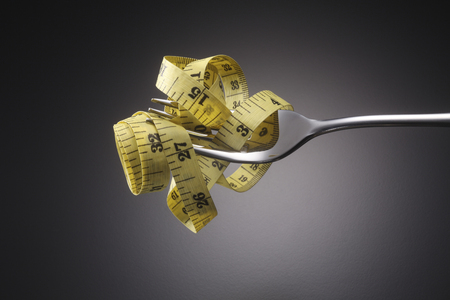 fork and measuring tape on the gray backgroundの写真素材