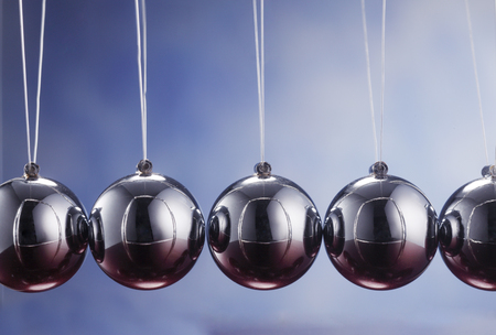 Newton's cradle against blue backgroundの写真素材