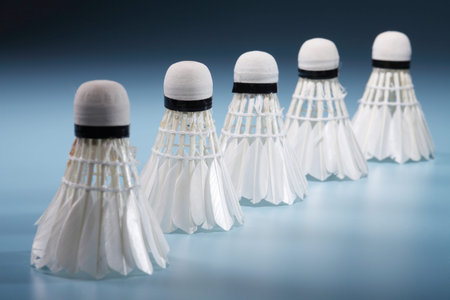 Badminton shuttlecocks in row on blue background
