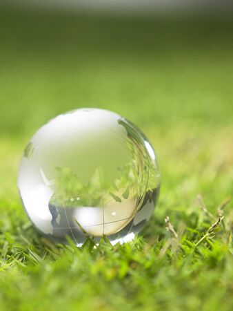 glass globe resting on the grassの写真素材