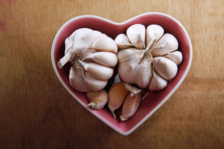 white garlic in the heart shaped bowlの写真素材