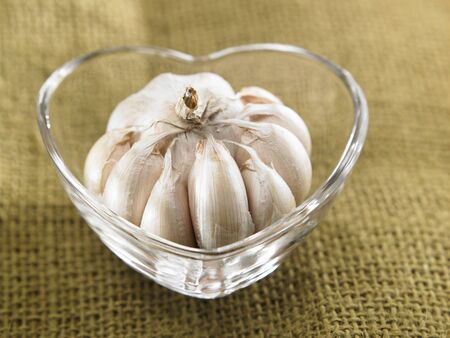 Garlic in a heart shaped bowlの写真素材