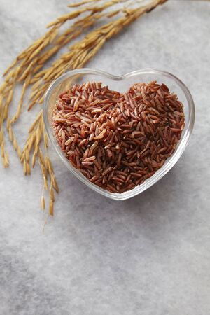 brown rice in a heart shape cointainerの写真素材