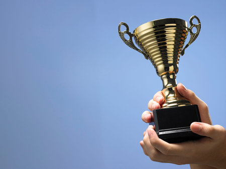 Man holding a champion golden trophy