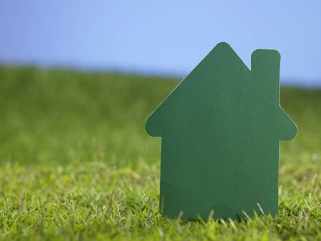 paper house resting on the grassの写真素材