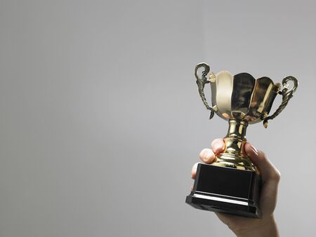 Man holding a champion golden trophyの写真素材