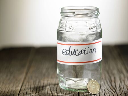 empty glass jar labelled with text educationの写真素材