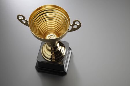 golden cup on the gray back groundの写真素材