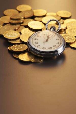 stop watch on pile of gold coinの写真素材