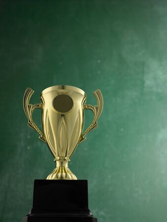 gold trophy against black boardの写真素材
