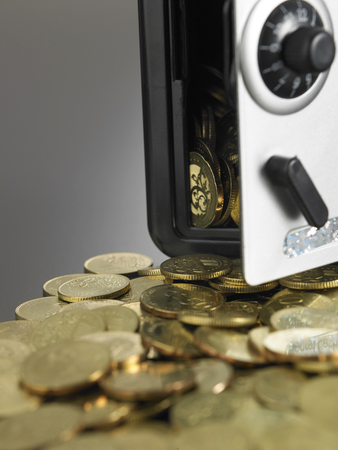 coins in front of the mini safe boxの写真素材