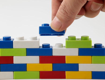 hand stack up brick set as a wall on white