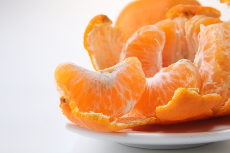 Peeled tangerine or mandarin fruit isolated on white backgroundの写真素材